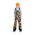 Obermeyer Junior's Carver Bib Pant 2025 - A pair of snow pants with a camouflage pattern in shades of brown, green, and white.