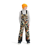 Obermeyer Junior's Carver Bib Pant 2025 - A pair of snow pants with a camouflage pattern in shades of brown, green, and white.