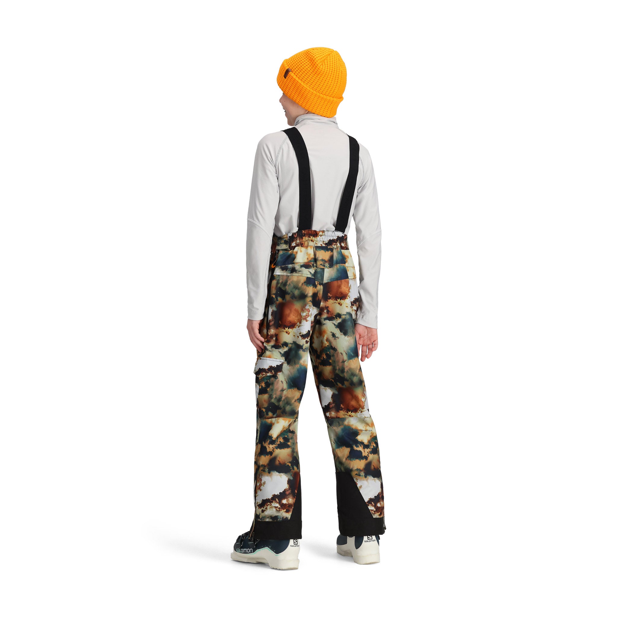 Obermeyer Junior's Carver Bib Pant 2025 - A pair of snow pants with a brown and black camouflage pattern, featuring a bib design and adjustable straps.