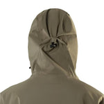 Beyond Medals Cargo Shell 2L Jacket 2025 - A khaki-colored jacket with a hood, featuring two zippered pockets on the front and a cargo pocket on one side.