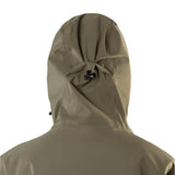 Beyond Medals Cargo Shell 2L Jacket 2025 - A khaki-colored jacket with a hood, featuring two zippered pockets on the front and a cargo pocket on one side.