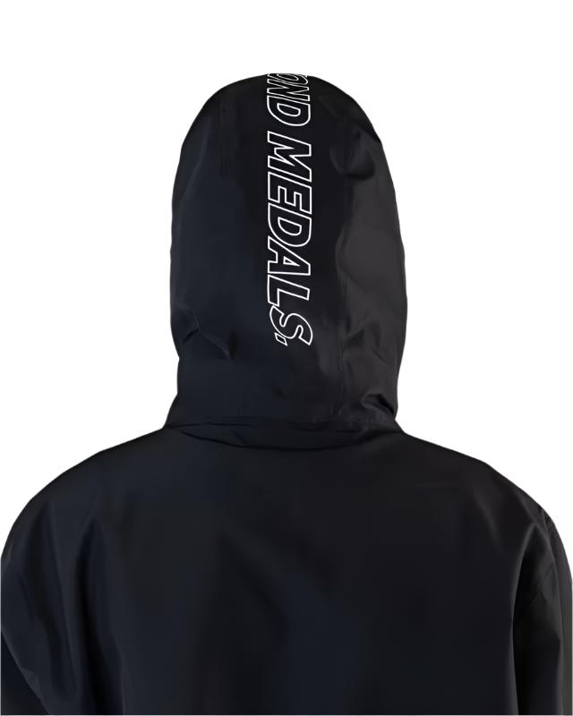 Beyond Medals The Jacket Shell 2025 - A black jacket with a white logo on the chest and a hood.
