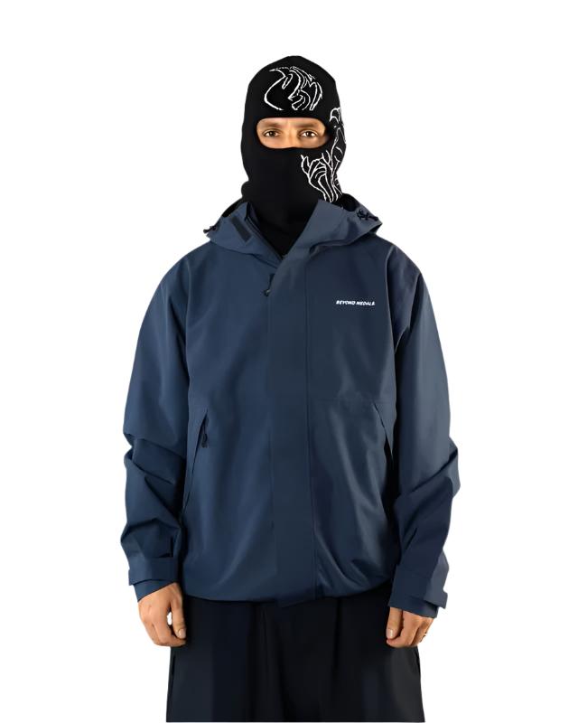 Beyond Medals The Jacket Shell 2025 - A black jacket with a white logo on the left chest and a zipper down the front.