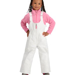 Obermeyer Junior's Snoverall Insulated Bib Pant 2025 - A young girl with curly hair is wearing a pair of white snow pants with adjustable straps and a zipper down the front, paired with a pink fleece jacket.