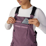 Women’s mauve purple insulated bib overalls with chest pocket, button straps, and utility details.