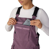 Women’s mauve purple insulated bib overalls with chest pocket, button straps, and utility details.