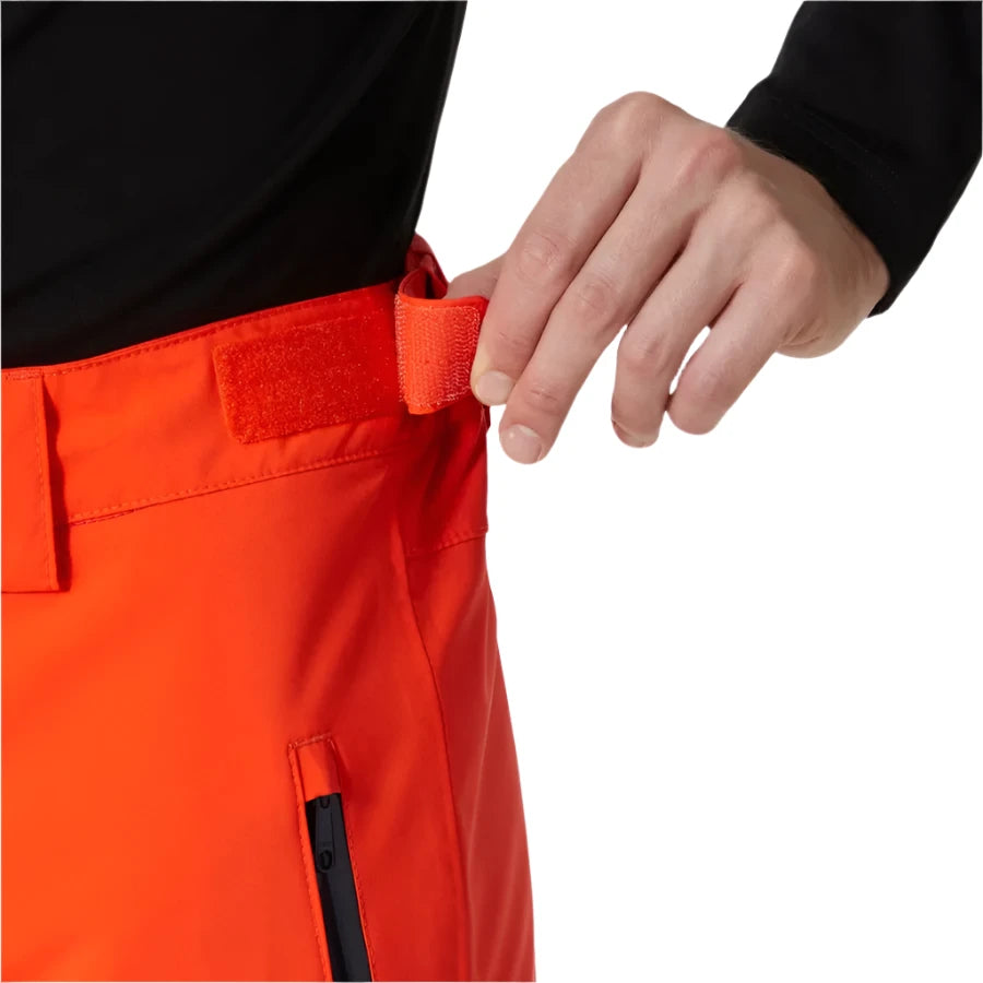 Hally Hansen Men's Legendary Insulated Pant - A pair of bright orange snow pants with a black zipper on the side pocket.
