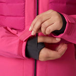Helly Hansen Women's Avanti Insulated Jacket - A woman's hand is adjusting a zipper on the sleeve of this bright pink jacket with a black zipper and two zippered pockets.