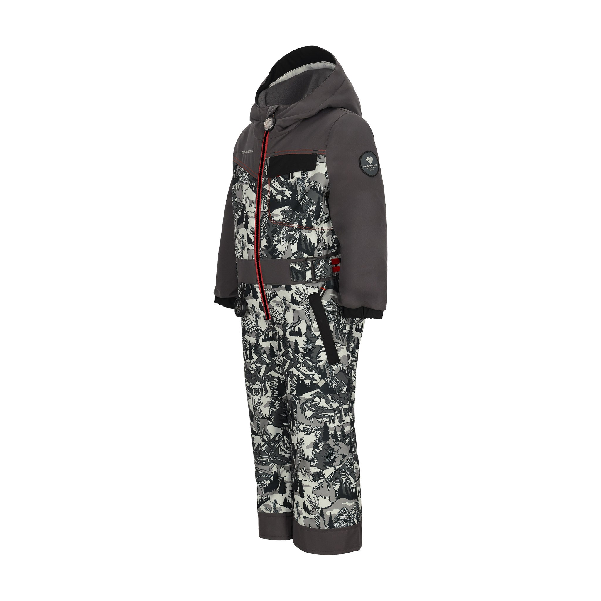 Obermeyer Junior's Quinn Insulated One-Piece Suit 2025 - A black and white snowsuit with a pattern of skiers, trees, and mountains.