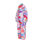 Obermeyer Junior's Quinn Insulated One-Piece Suit 2025 - A white snowsuit with a colorful abstract pattern of pink, purple, blue, and orange shapes.