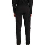 Obermeyer Junior's UltraGear Bottom 2025 - Black snow pants with a subtle white stripe on the left leg, worn by a model from behind.