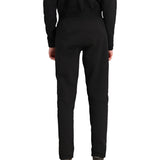 Obermeyer Junior's UltraGear Bottom 2025 - Black snow pants with a subtle white stripe on the left leg, worn by a model from behind.