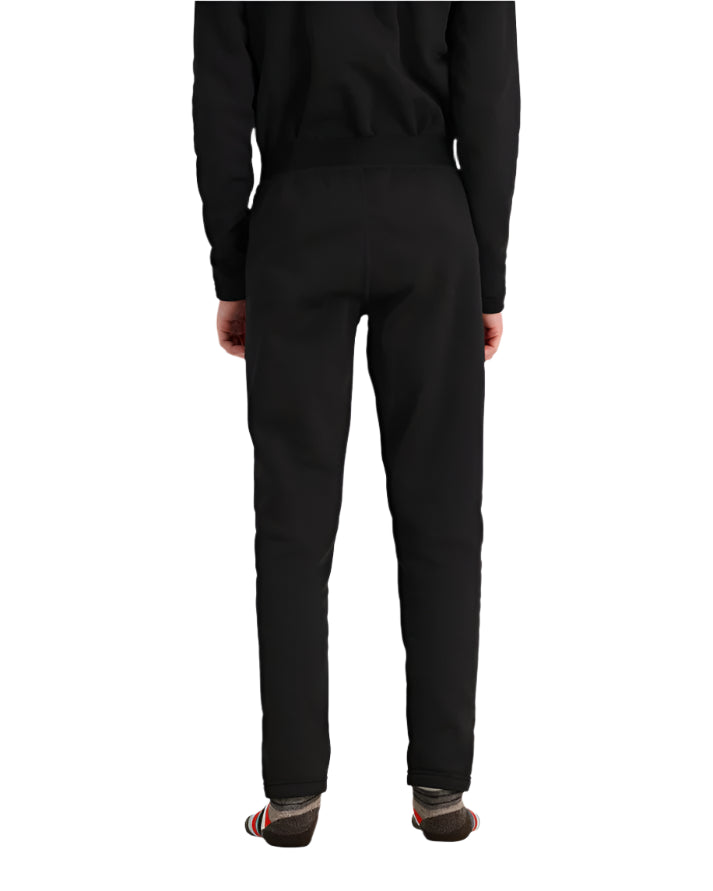 Obermeyer Junior's UltraGear Bottom 2025 - Black snow pants with a subtle white stripe on the left leg, worn by a model from behind.