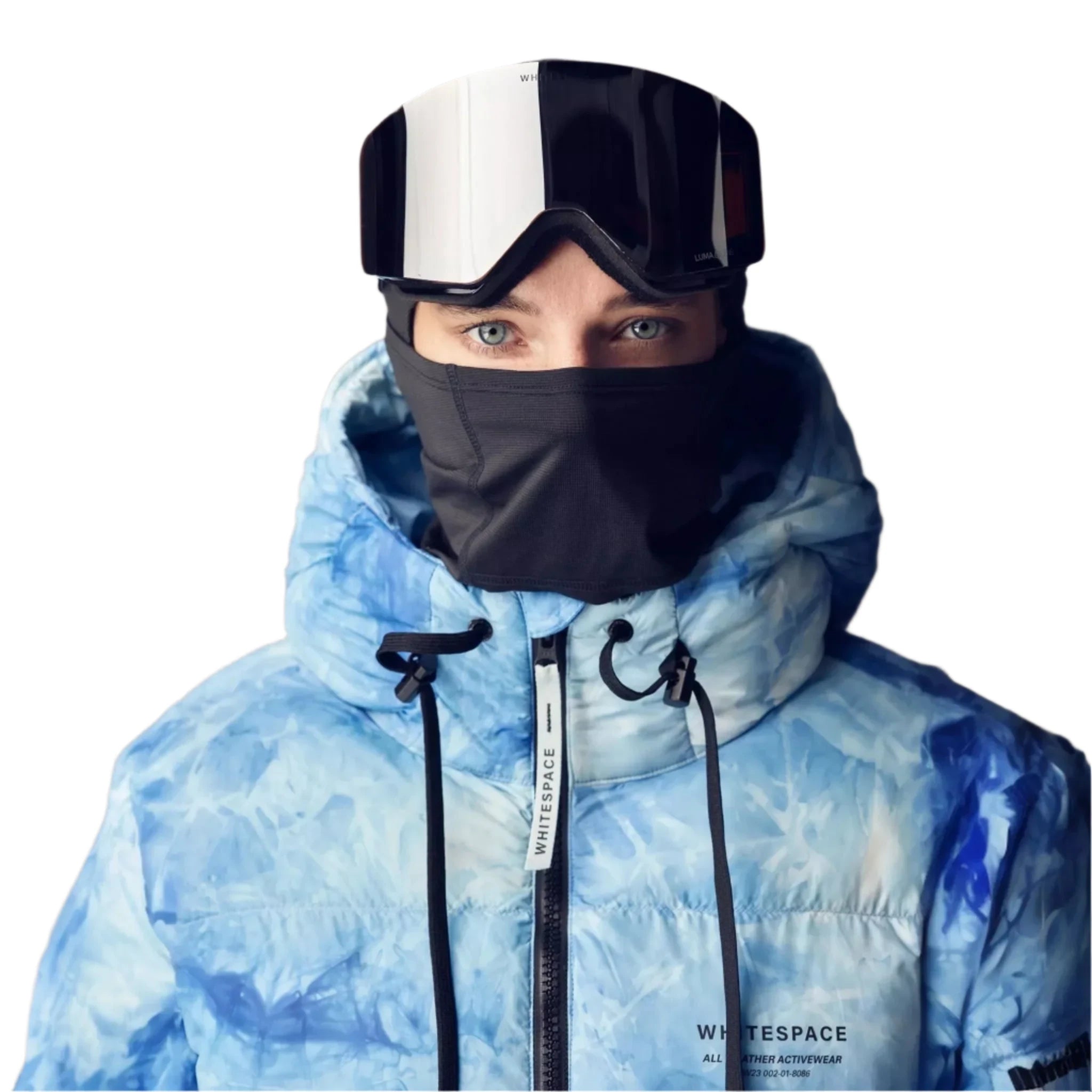 Whitespace Women's Cropped Puffer Jacket 2024 - A woman wearing a black balaclava and white ski goggles with black frames, posing in front of a gray background while wearing a cropped puffer jacket that is light blue with a subtle pattern.