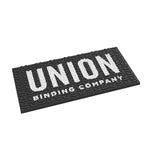 Union Surf Stomp Pad 2025 - Black surfboard pad with a textured surface and white logo on top.