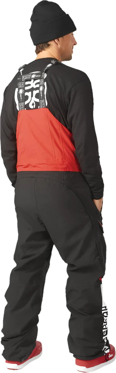 ThirtyTwo Spring Break x Powder Shell Bib 2024 - Black bib with white and red accents, featuring a palm tree design on the back.