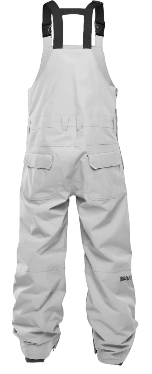 ThirtyTwo Basement Shell Bib Pant 2025 - White bib pants with black straps and a zippered pocket on the thigh.