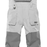 ThirtyTwo Basement Shell Bib Pant 2025 - A pair of light gray snowboard pants with a reflective logo on the left thigh and a zippered pocket on the right hip.