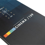 Nitro Cinema Snowboard 2025 - A black snowboard with a white logo featuring a film strip and camera lens, set against a gray background.