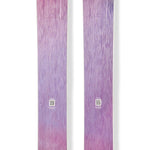 Purple and pink downhill skis with circular logo decals on the top surface.