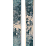 Teal skis with gold trim and circular brand logos, full-length pair.