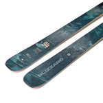 Teal skis with gold edges and printed 94 marking, close-up of tips.