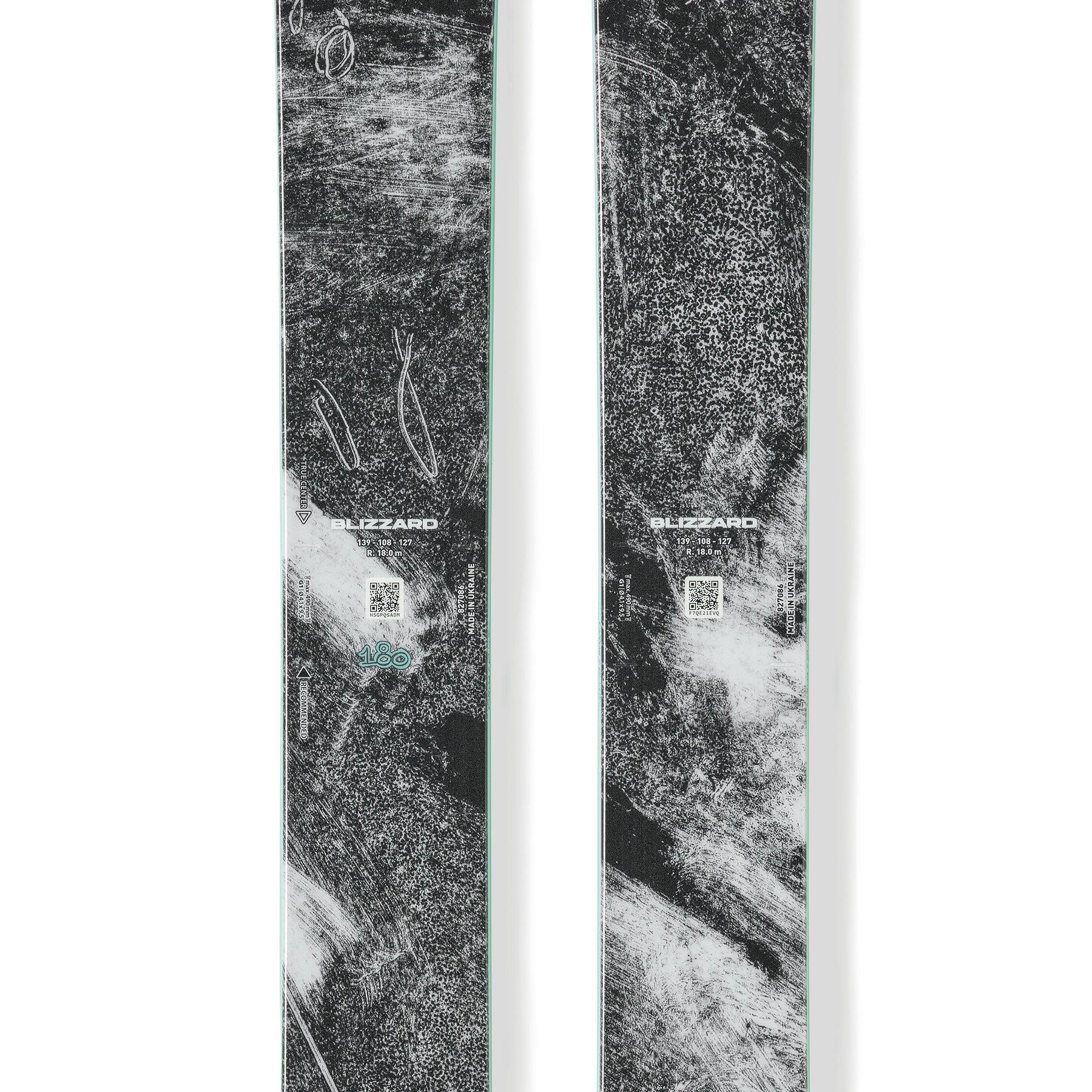 Pair of black skis with teal logo, mint edge, and textured graphic tops.