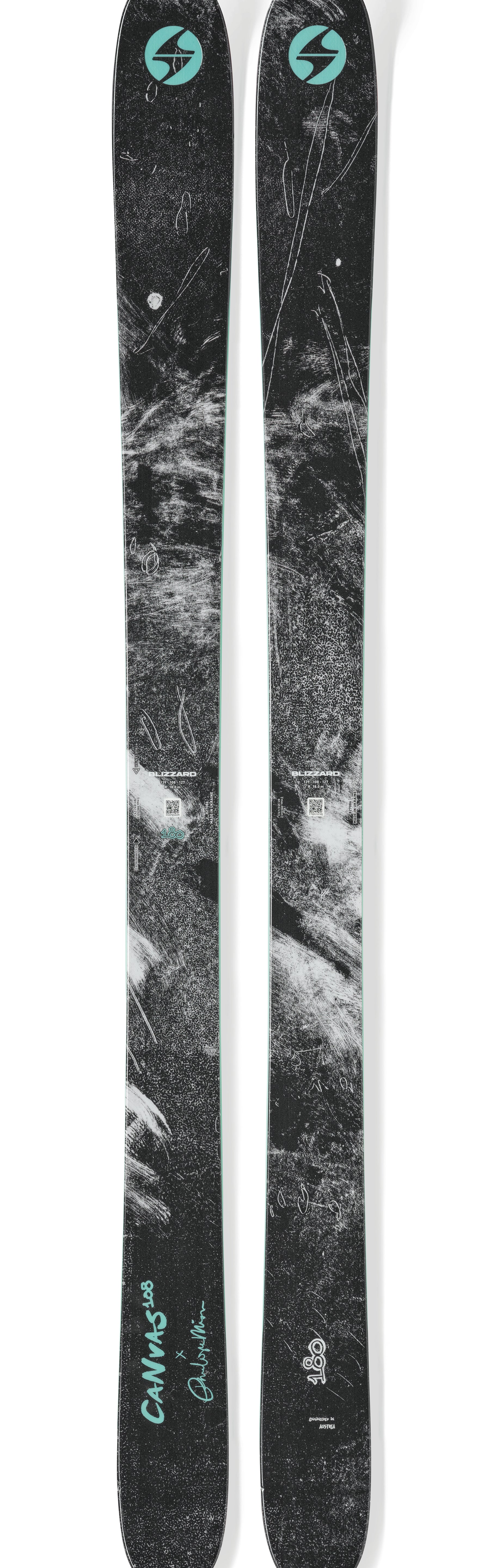 Pair of black skis with teal logo, mint edge, and textured graphic tops.