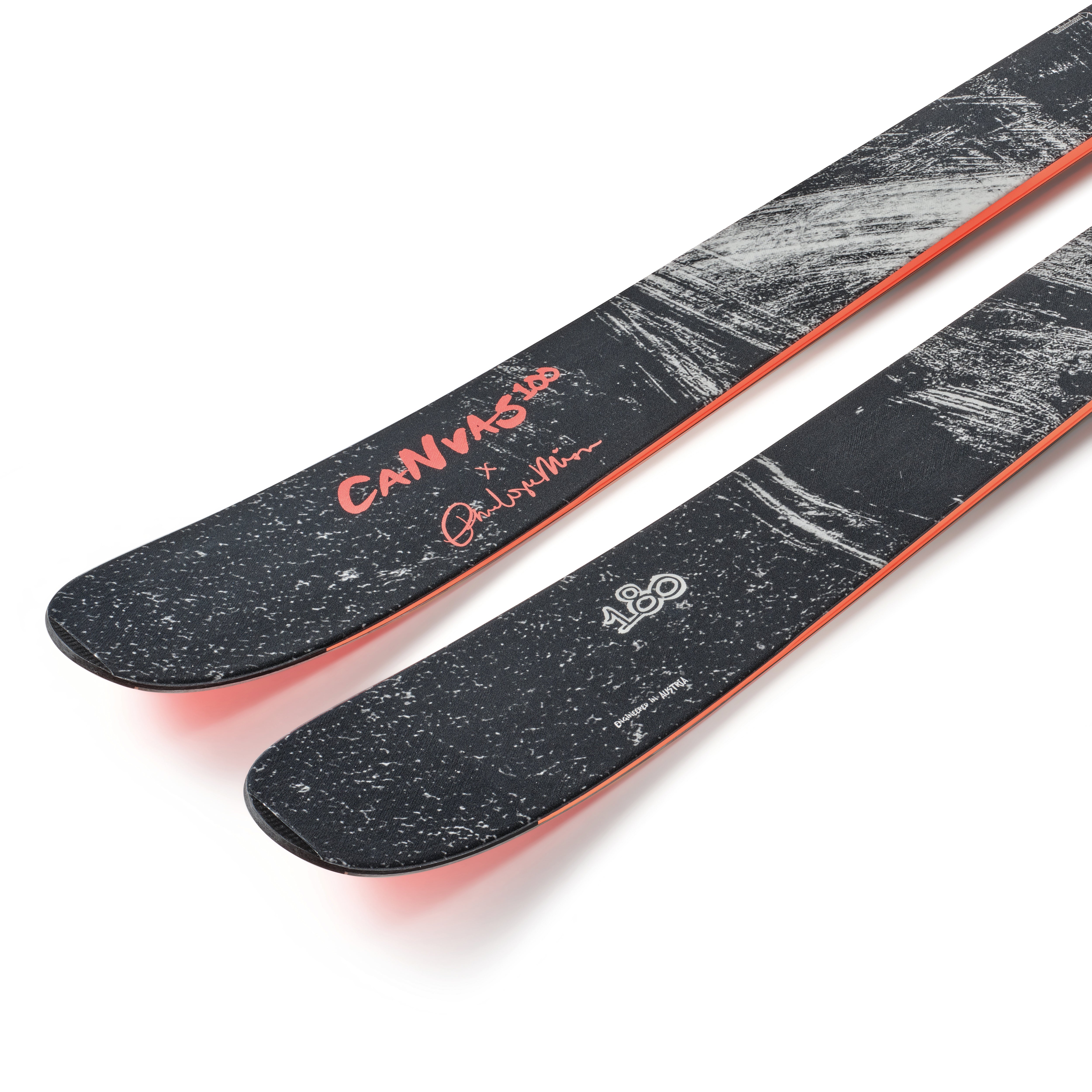 Skis with black speckled tops, orange trim, and Canvas branding near the tips