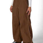 Brown shell pants with belt loops, side pockets, and relaxed wide legs