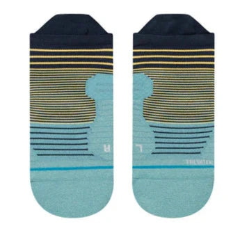 Stance Flounder Tab Ankle Sock 2023 - A pair of ankle socks with a light blue base and yellow stripes, featuring a flounder tab at the top.
