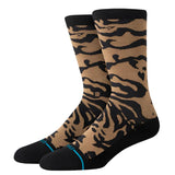 Stance Animalistic Crew Sock 2024 - A pair of tan crew socks with a black zebra-like pattern and blue accents on the toes.