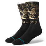 Stance X Queen Golden Crew Socks 2024 - A pair of black crew socks with a gold foil Queen logo on top and a repeating pattern of the same logo along the sides.