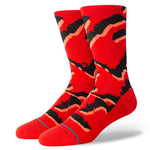 PELTER CREW SOCK 2024 - A pair of red crew socks with a black and orange abstract pattern on them.