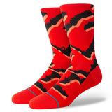 PELTER CREW SOCK 2024 - A pair of red crew socks with a black and orange abstract pattern on them.
