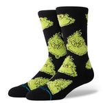 Stance Mean One Crew Sock 2025 - A pair of black crew socks with a repeating pattern of green Grinch faces.