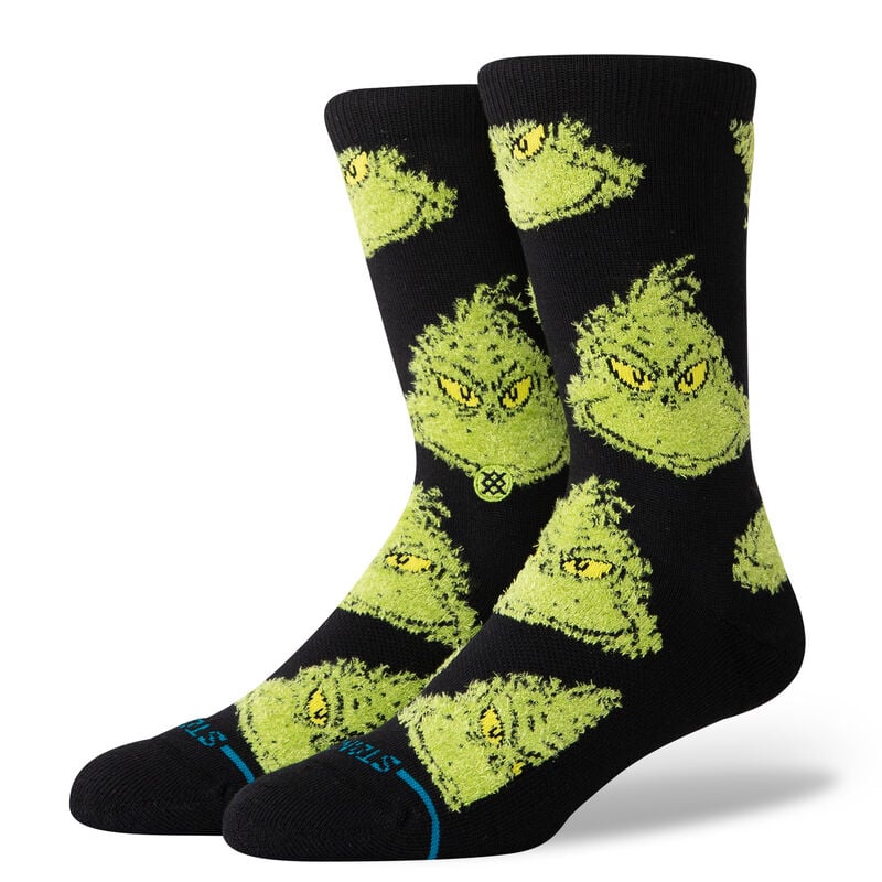 Stance Mean One Crew Sock 2025 - A pair of black crew socks with a repeating pattern of green Grinch faces.