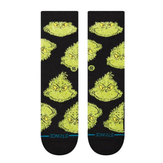Stance Mean One Crew Sock 2025 - A pair of crew socks featuring a cartoonish illustration of the Grinch's face in green with yellow eyes and eyebrows, on a black background.