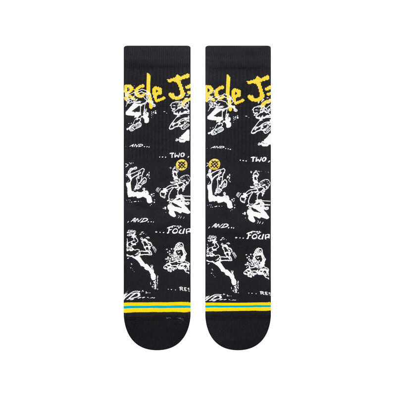 Stance Circle Jerks X Stance Crew Socks 2023 - Black crew socks with white and yellow graphics of a man playing guitar, featuring the words "Circle Jerks" in yellow at top.