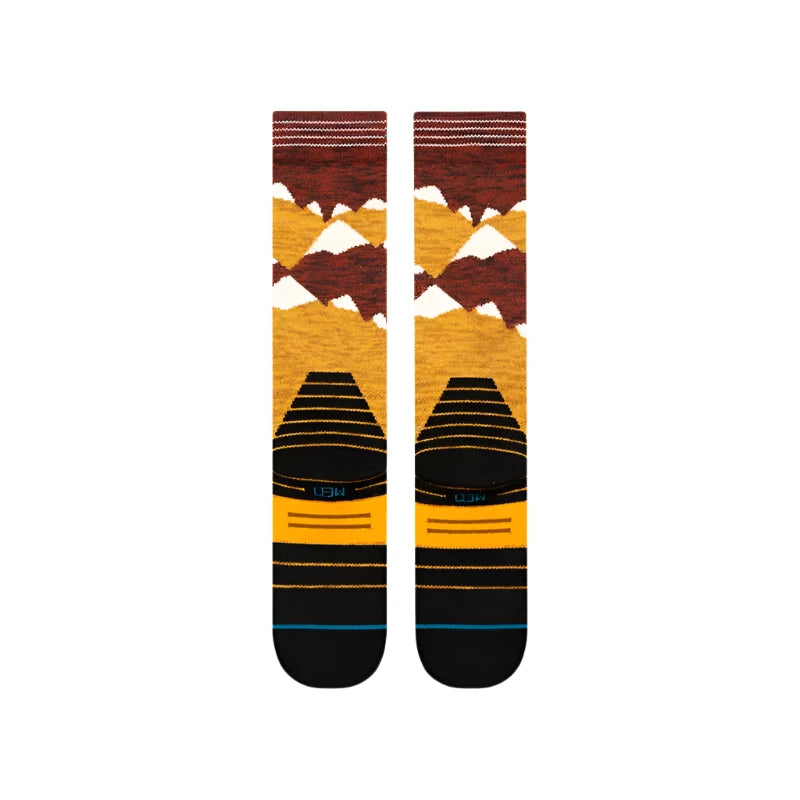 Stance Windy Peaks Snow Sock 2025 - A pair of snow socks with a brown and yellow pattern featuring white peaks.