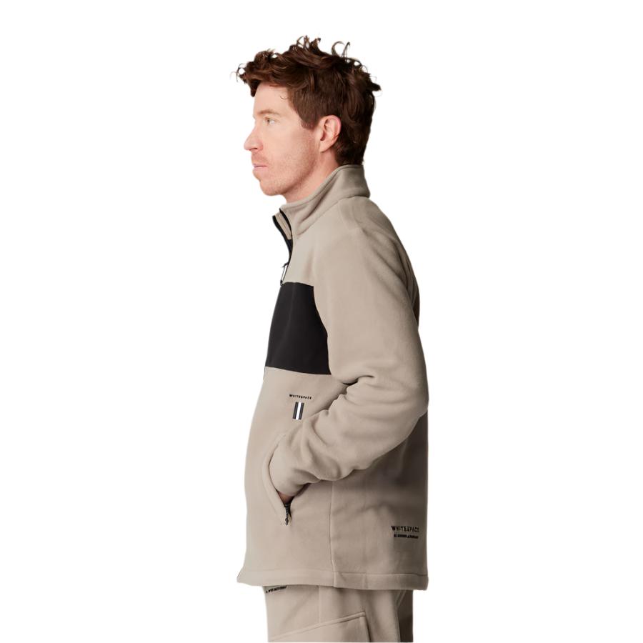 Whitespace Apres Polar Fleece Zip Jacket 2024 - A tan fleece jacket with a black stripe across the chest and two zippered pockets on the front.