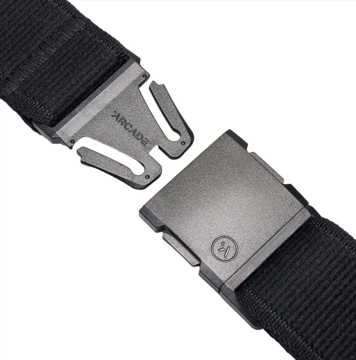 A close-up of a black belt with a plastic buckle. The buckle is detached, revealing the word 'ARCADE' embossed on the male end and a small logo on the female end.