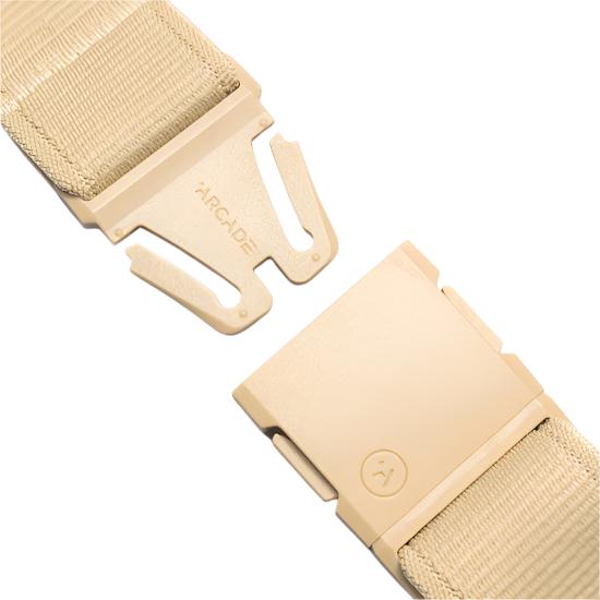 Arcade Atlas Stretch Belt 2025 - Beige belt with a textured pattern on the strap and a small logo on the buckle.