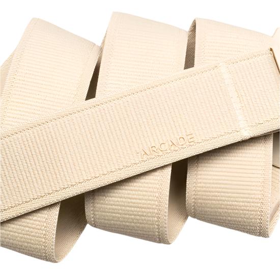Arcade Atlas Stretch Belt 2025 - Beige belt with a subtle grid pattern on the fabric, featuring an adjustable buckle and a relaxed fit.