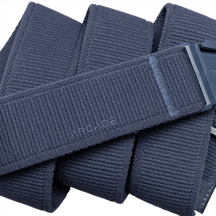 Close-up of a navy blue belt showing the textured fabric and the brand name 'ARCADE' embossed on it.