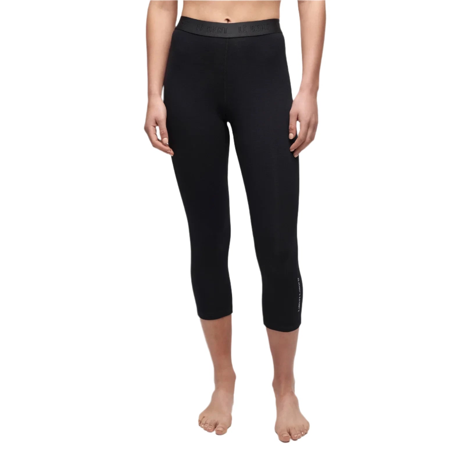 Le Bent Women's Core Lightweight 3/4 Bottom Base Layer - A pair of black women's leggings with a high waistband and three-quarter length, featuring a subtle logo on the left leg.