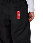Black boys' shell pants with elastic waist and red logo patch on pocket