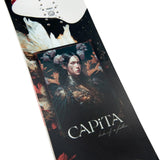 CAPiTA Women's Birds of a Feather Snowboard 2025 - A black snowboard with white and red feathers, flowers, and a woman's face on it.