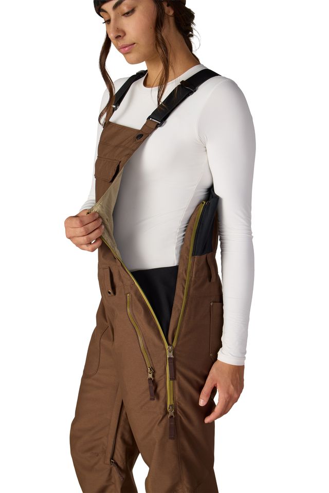 Women’s insulated brown bib overalls with side zipper opening and contrast inner panel.
