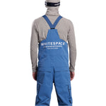 Whitespace 2L Cargo Insulated Bib Pants 2024 - A pair of blue bib pants with cargo pockets on each thigh and a white logo on the left leg.